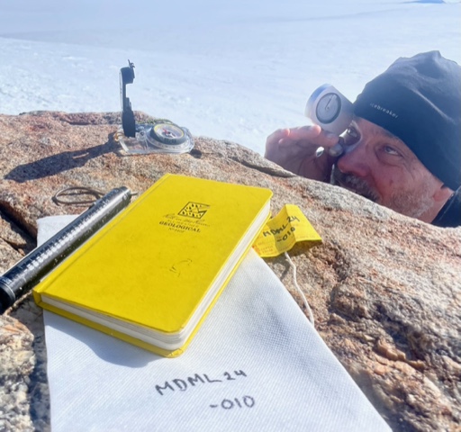 En man riktar ett instrument mot horisionten. 