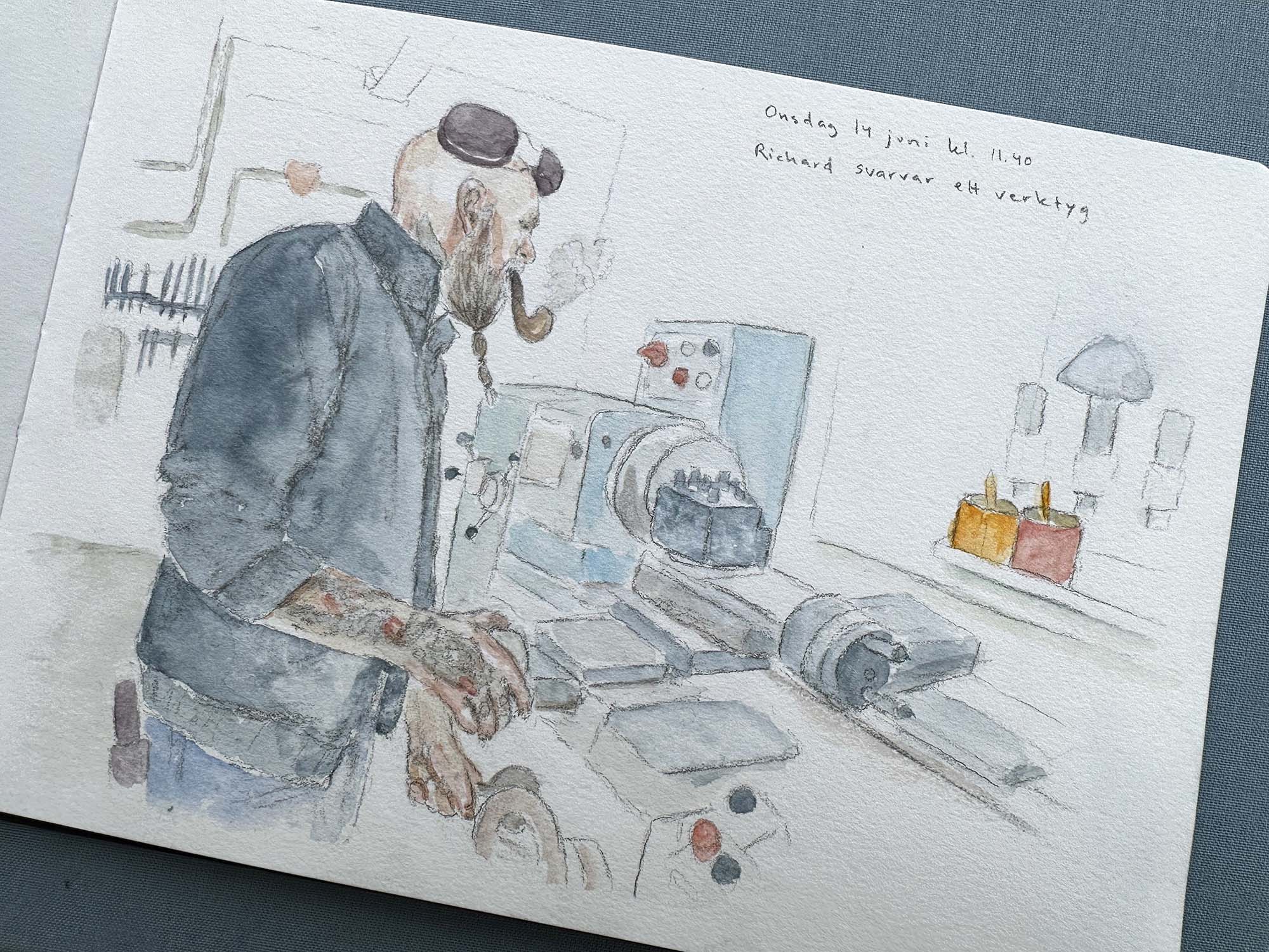 Peson i blå kläder står vid en svarv