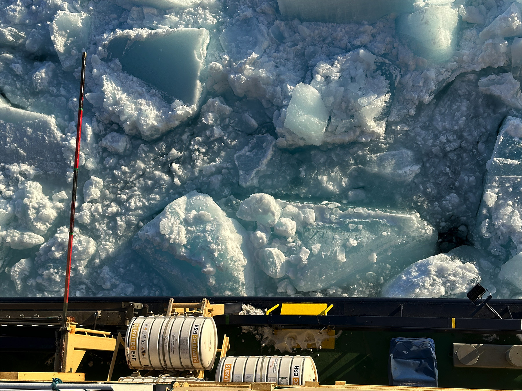 Stora flak av blå krossad is utanför Odens reling