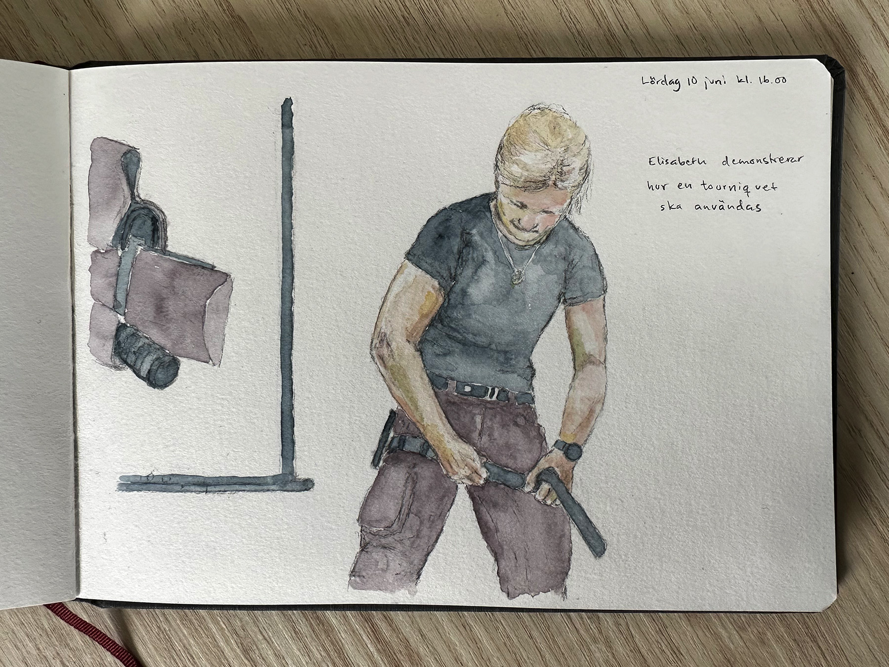 En kvinna drar åt ett band runt benet för att visa hur en blödning stoppas