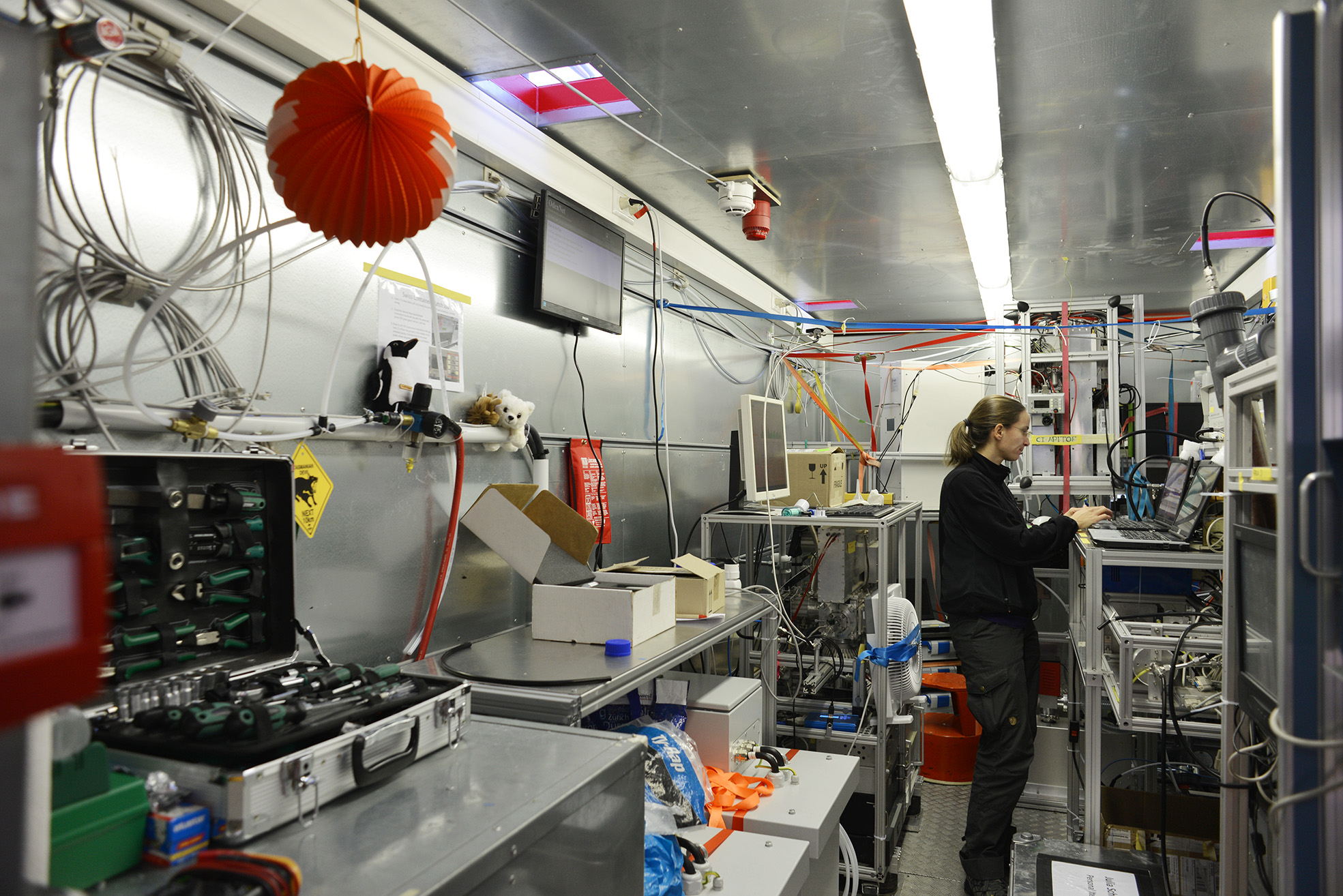 Julia Schmale arbetar i den schweiziskska lab-containern. I bakgrunden instrument för att mäta aerosoler